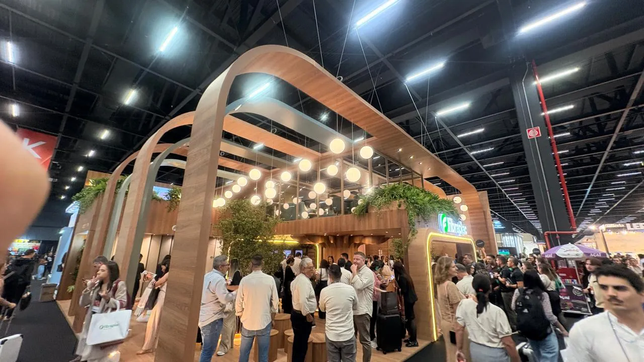 Stand em madeira com arcos e iluminação em pavilhão de feira